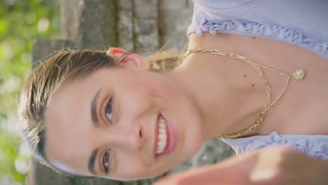 vertical video of young woman looking into camera and making peace sign