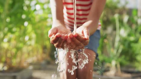 Focus-on-african-American-girl-washing-her-hands-outside