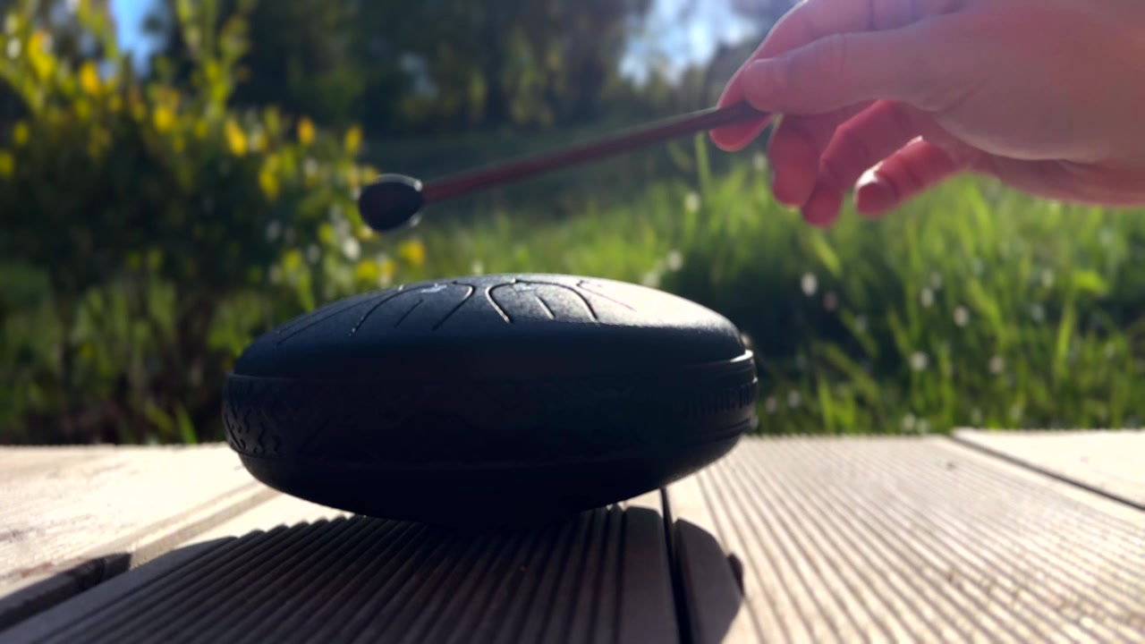 Person som spiller ståltromme utendørs i sollys