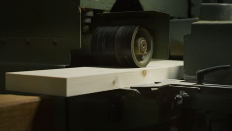 primer plano de una plancha industrial que trabaja con troncos en una fábrica de madera o aserradero.