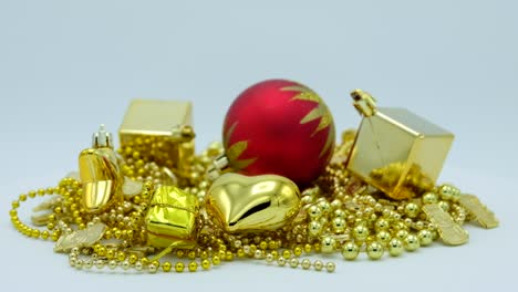 golden christmas decoration and red ball with star rotating on white background.