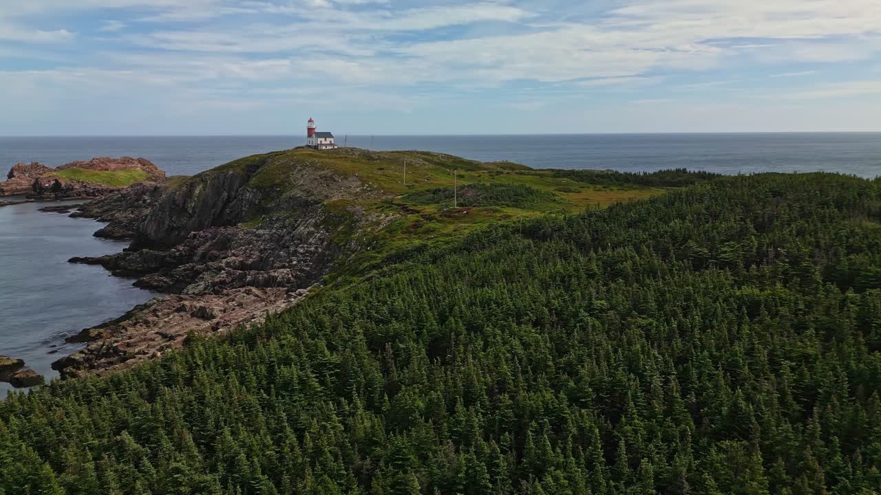 Drooni lentää rehevän, metsäisen niemekkeen yllä Newfoundlandin rannikolla paljastaen pienen majakan niemimaan kärjessä ja sitä ympäröivät siniset Atlantin vedet.