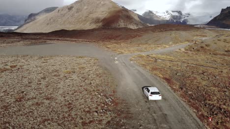 tight aerial follow shot of a car driving towards a glacier