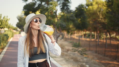 woman enjoying a drink in a park