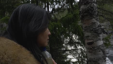 girl watching beautiful waterfall in the forest