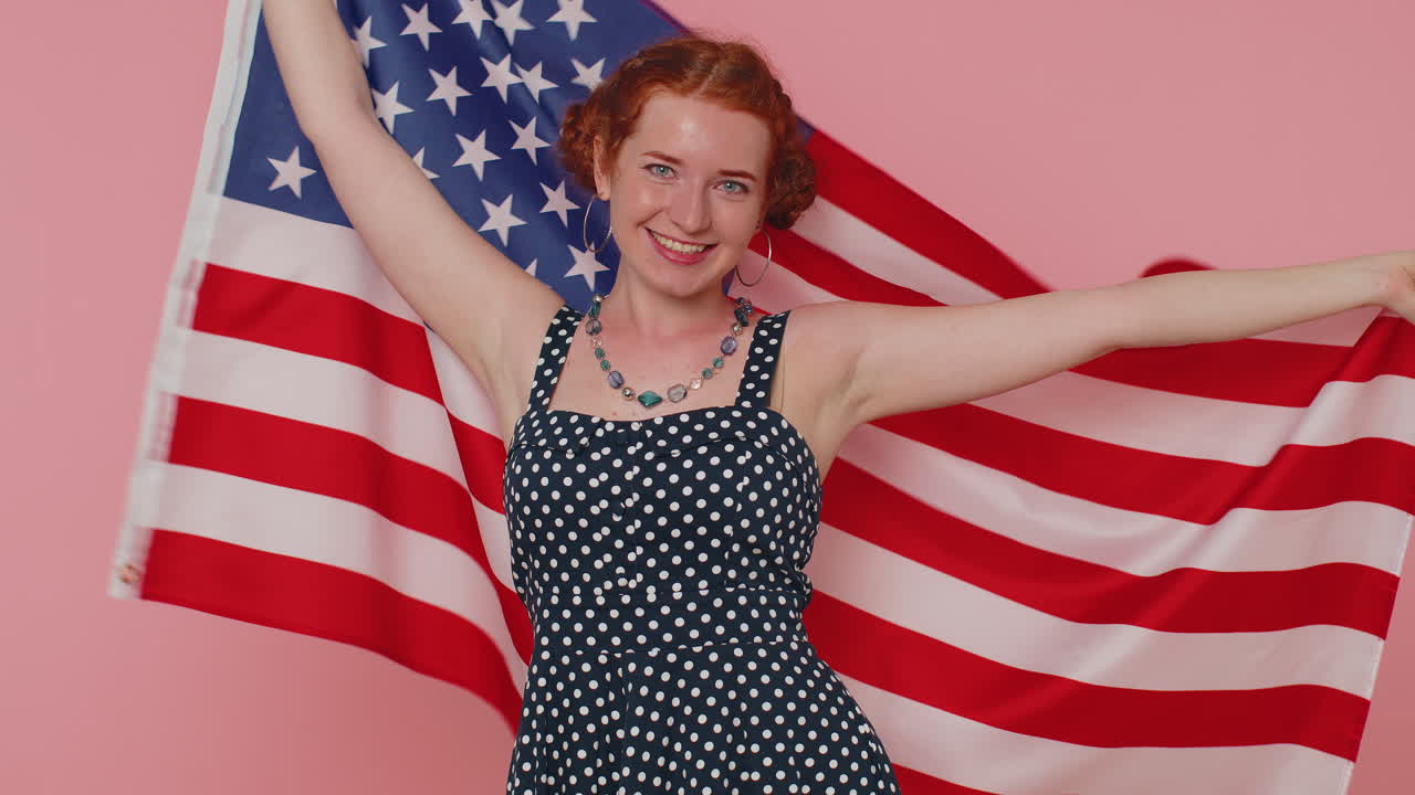 Giovane donna che sventola e si avvolge nella bandiera degli Stati Uniti d'America, festeggiando i diritti umani e le libertà