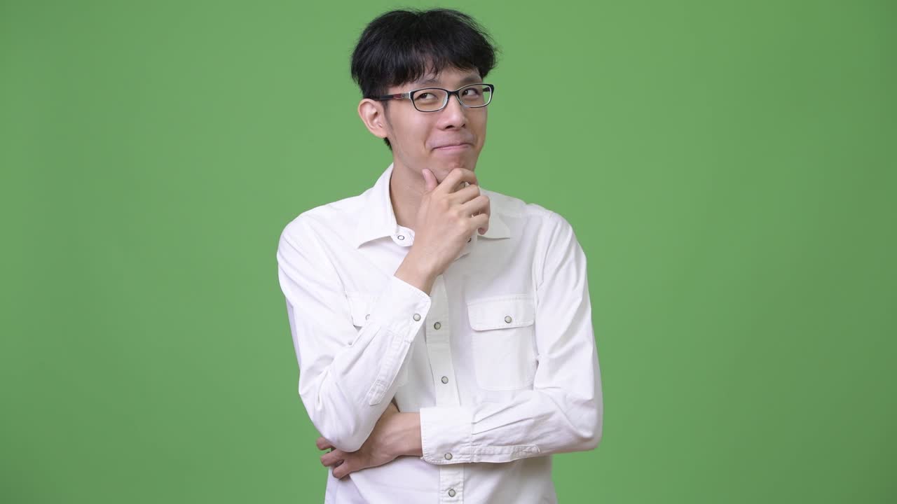 젊은 행복한 아시아 사업가 생각하면서 웃고