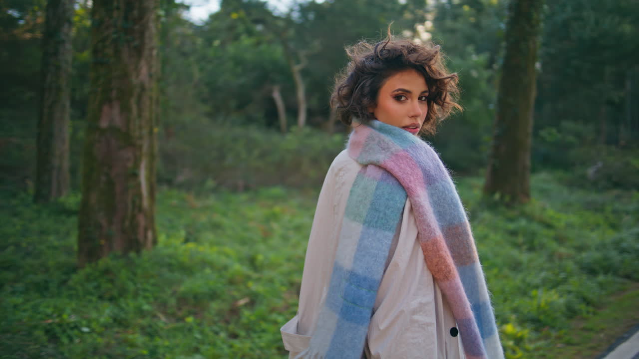 mujer elegante paseando por la carretera del parque en un primer plano de bufanda. viajero caminando por el bosque