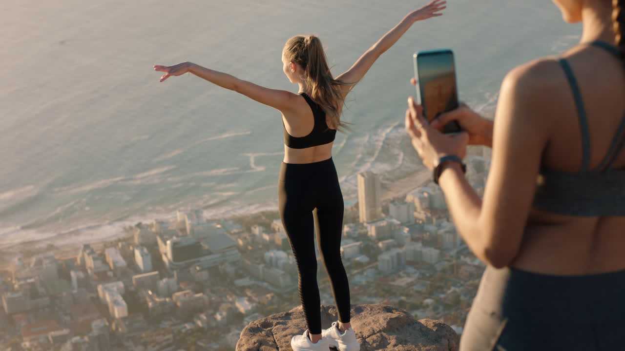 amigas tomando fotos en la cima de la montaña usando la cámara del teléfono inteligente hermosa mujer joven posando para un amigo con el teléfono móvil compartiendo la aventura de senderismo en las redes sociales