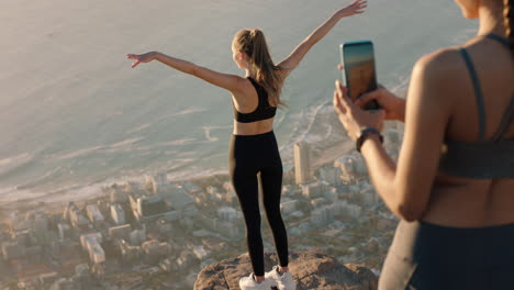 amigas tomando fotos en la cima de la montaña usando la cámara del teléfono inteligente hermosa mujer joven posando para un amigo con el teléfono móvil compartiendo la aventura de senderismo en las redes sociales