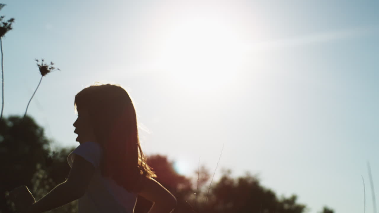 ребёнок бежит по полю при заходе солнца.