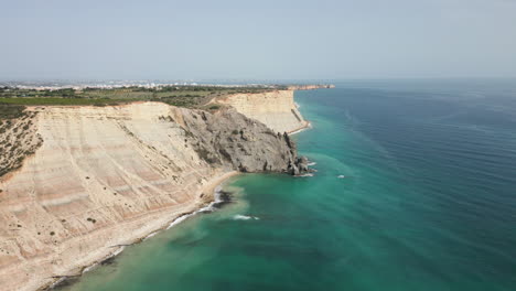 forward flying drone shot of the cliffs at luz portugal