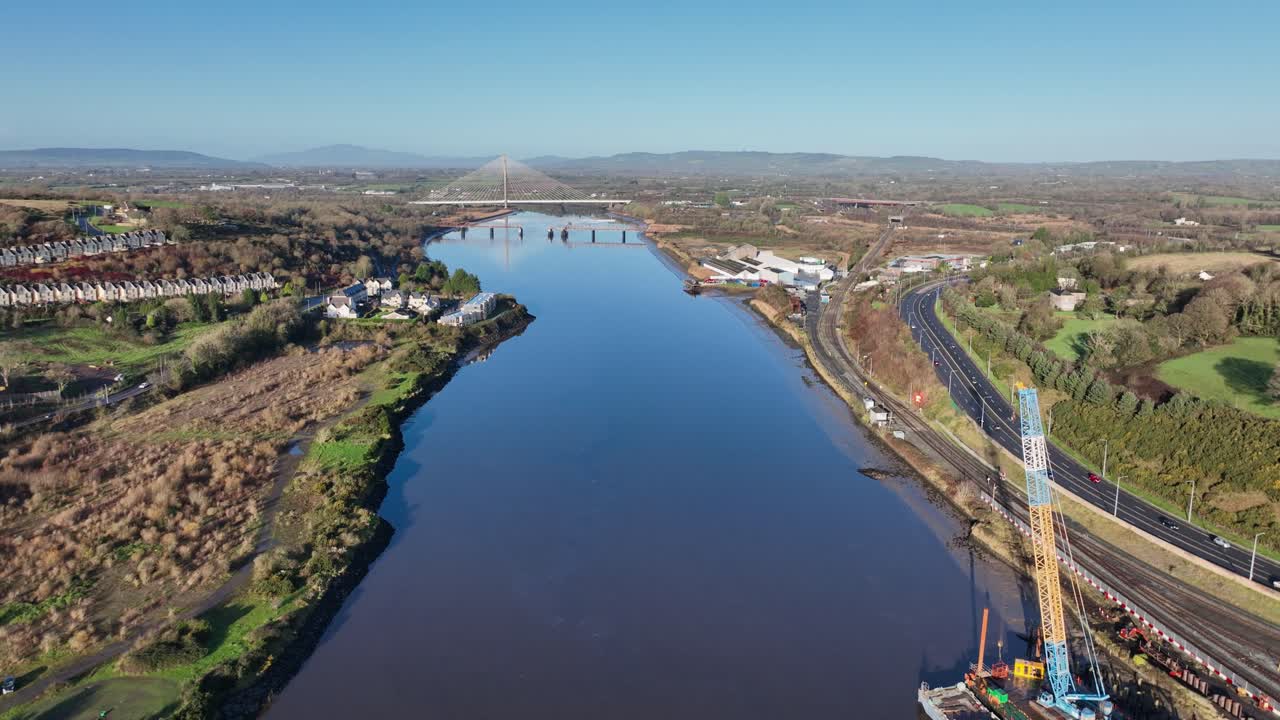 Waterford and Suir River Ireland drone pullback and barge doing riverside repairs on railway line autumn morning