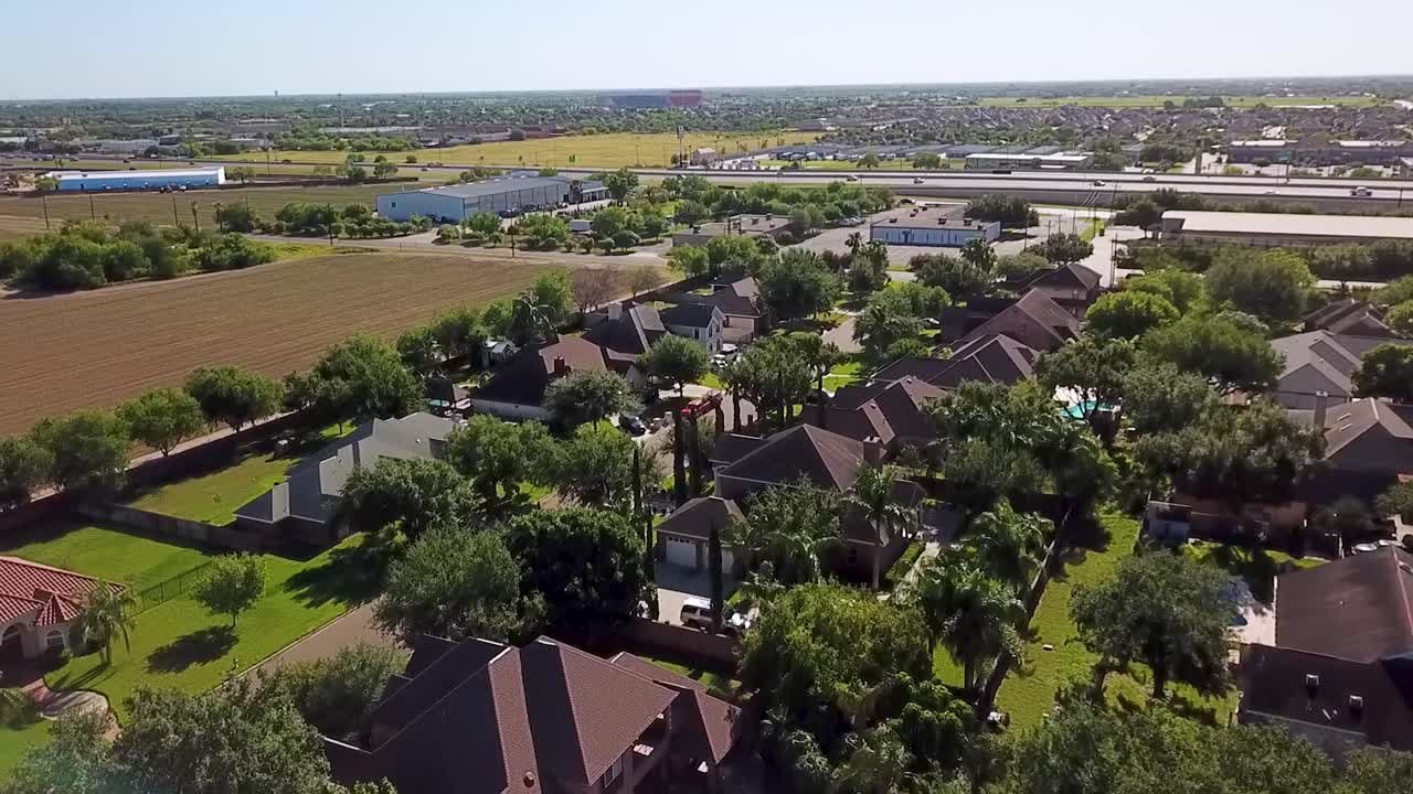 Drone flight and video footage over the residential area of Edinburg, on the outskirts of McAllen, Texas, with Freeway 69C in the background on a sunny Saturday morning