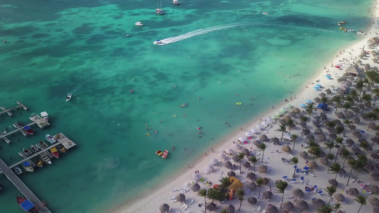 turistas en una playa y nadando en el mar caribe en aruba