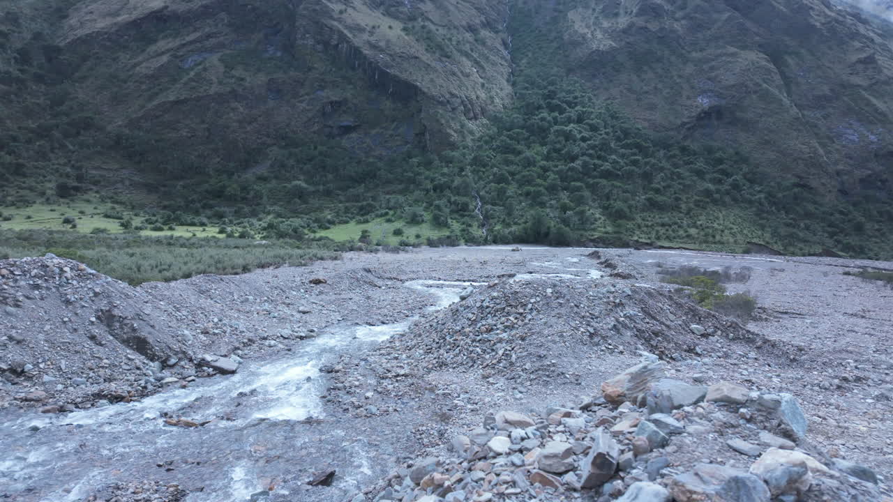 Hikers walking mountain trail toward Humantay peak and turquoise lake