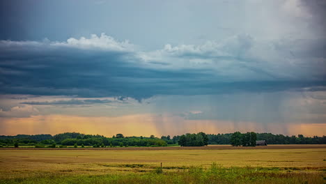 Zeitraffer,-Dunkle-Regnerische-Nimbostratus-Wolken,-Die-Sich-über-Einem-Farbenfrohen-Landschaftsfeld-Mit-Ankommendem-Regen-Ausbreiten