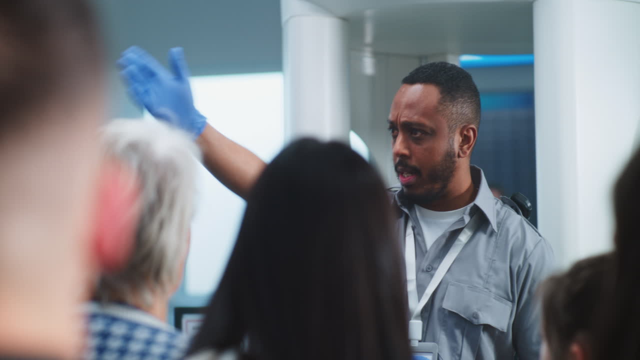 oficial de seguridad del aeropuerto guiando a los pasajeros