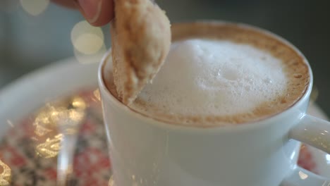 dipping a cookie into a coffee