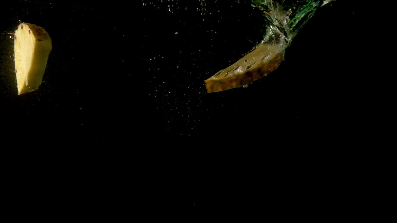 rodajas de piña jugosas deslizándose dentro de agua oscura y clara
