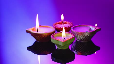 Close-up-of-burning-candles-celebrating-diwali-on-blue-background