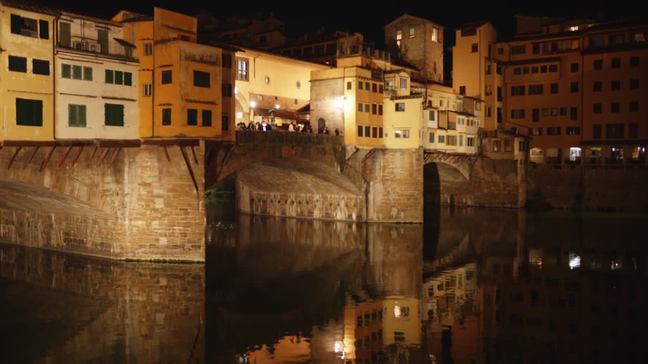 Ponte Vecchio en Florencia iluminado de noche con reflejos