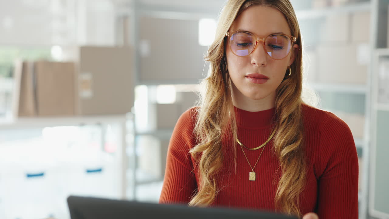 mujer trabajando en un almacén con una computadora portátil