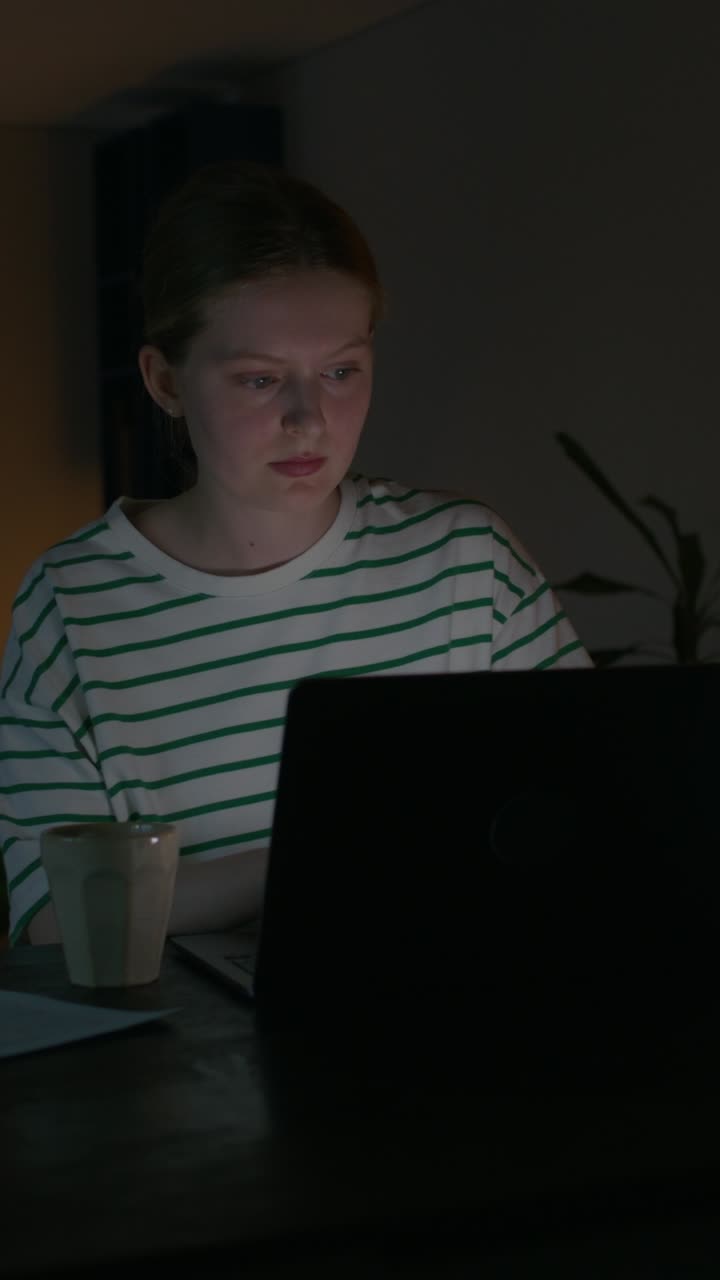 mujer joven trabajando tarde en la noche en la computadora portátil