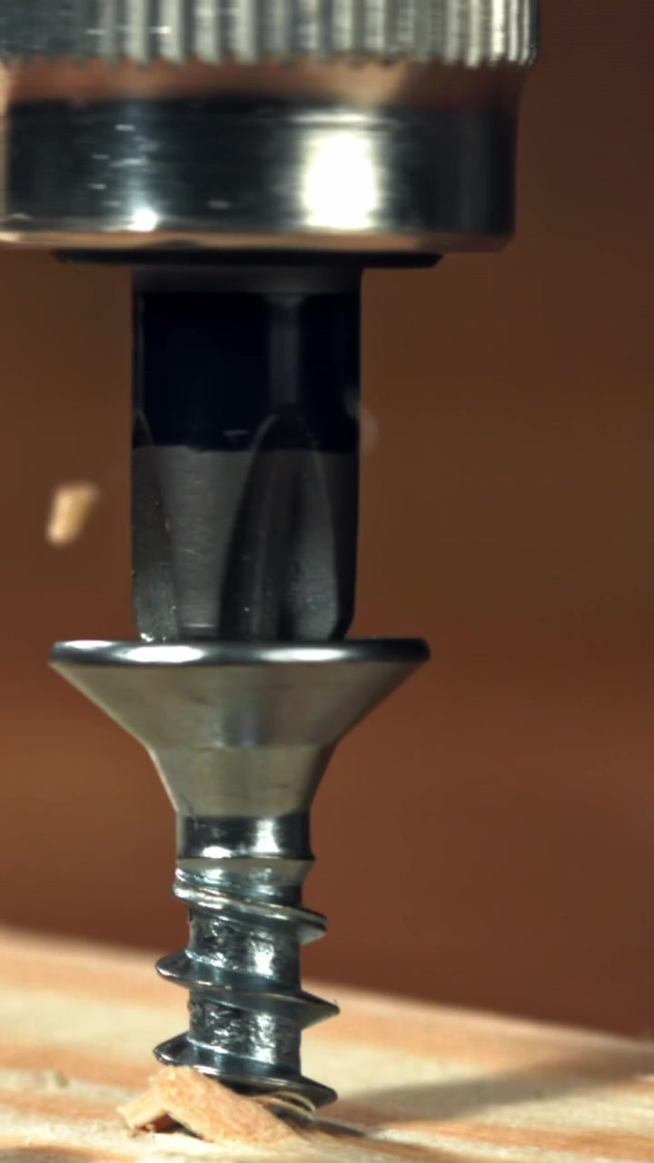 Slow Motion Close-Up of a Screw Being Driven into Wood