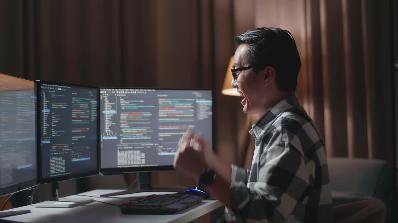 programador masculino asiático celebrando el éxito en la creación de ingeniero de software desarrollando aplicaciones, programas, videojuegos en computadora de escritorio en el hogar. terminal con lenguaje de codificación