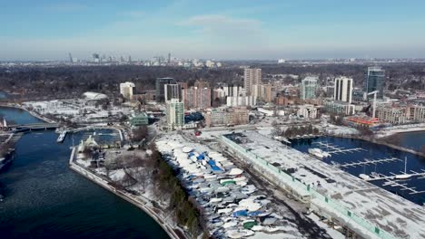 drone flying in winter towards a snowy downtown mississauga on lake ontario