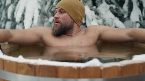 Caucasian-man-during-the-winter-bath-in-tube-outdoors.