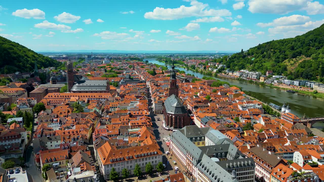 4K Aerial Drone Video of the Beautiful Homes with Red Terracotta Tile Roofs and Historic Heiliggeistkirche Church along the Neckar River in Heidelberg, Germany