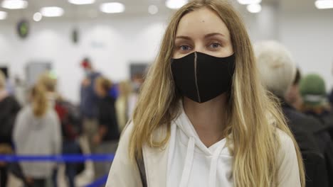Weibliche-Reisende-Mit-Schwarzer-Gesichtsmaske-Gehen-Und-Warten-Auf-Den-Check-in-Am-Flughafen