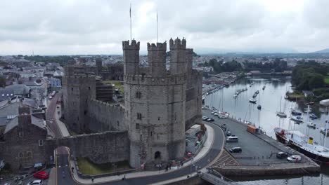 ancient caernarfon castle welsh harbour town aerial view medieval waterfront landmark closeup orbit right