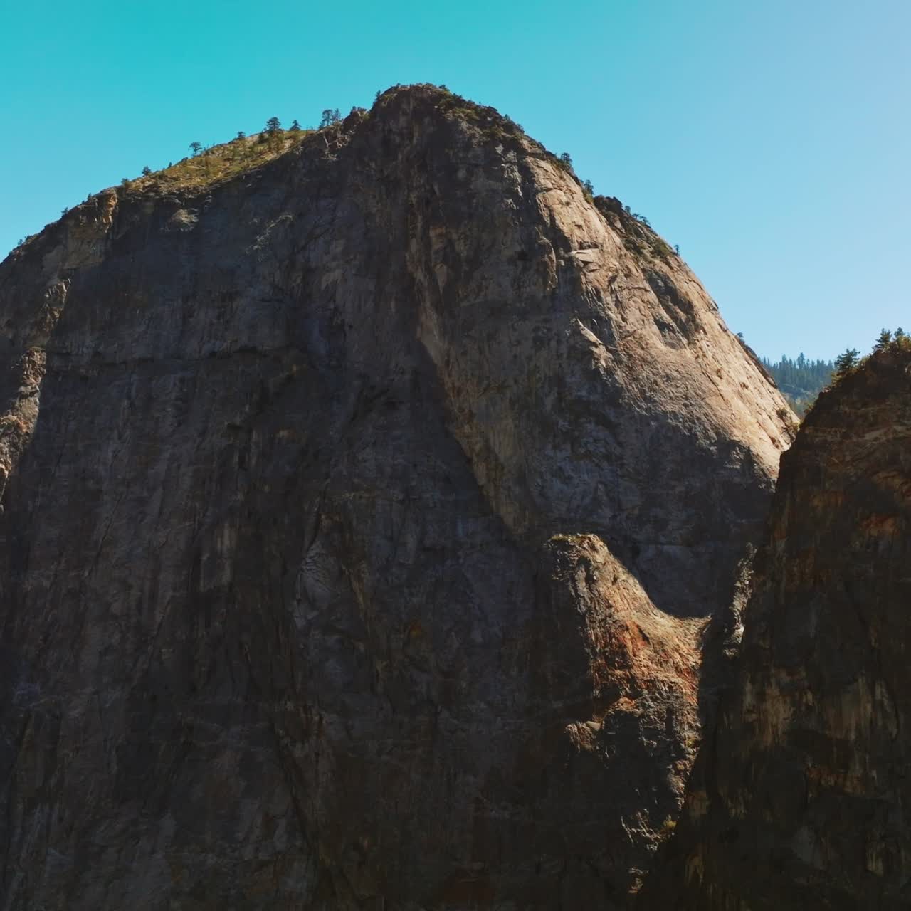 Enormous cliffs at the backdrop of blue clear sky. Yosemite National Park, California, United States on sunny daytime