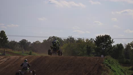 several quad bikes jump over the hill during race