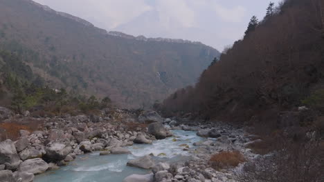 aerial view of dudh koshi river flowing through hilly terrain of nepal under clear sky, perfect for tourism, serenity, and adventure visuals