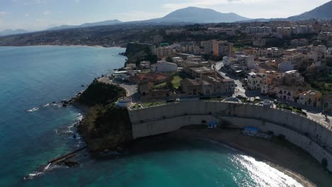 aerial view over cala petrolo beach with towering walls in castellammare del golfo