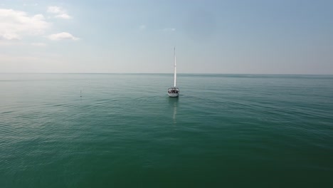 una hermosa toma cinematográfica de un avión no tripulado volando alrededor de un velero sobre el mar mediterráneo.