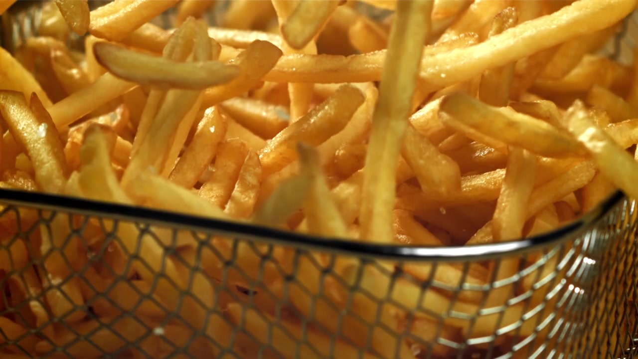 Crispy Golden French Fries Being Poured into a Basket