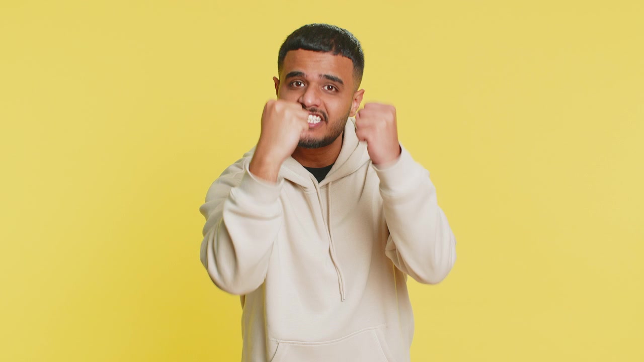 Aggressive angry indian man trying to fight at camera shaking fist boxing punishment threaten