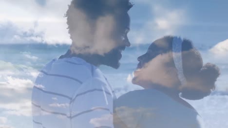 Animation-Von-Wolken-über-Einem-Afroamerikanischen-Paar-Am-Strand