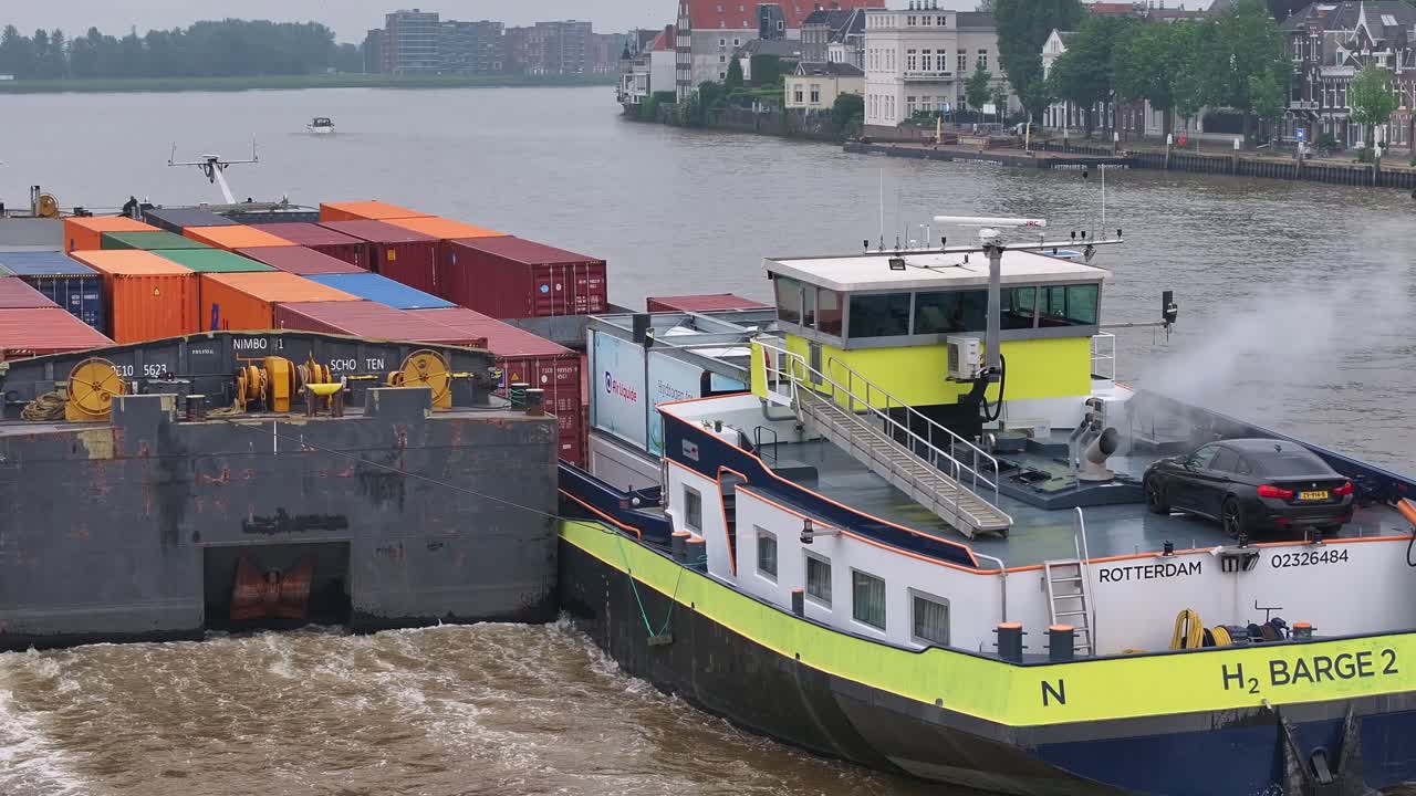 Barges Carrying Containers and a Car on a River in Rotterdam