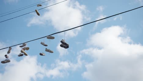 Zapatos-De-Adolescentes-Universitarios-Colgando-De-Las-Líneas-Eléctricas-Hacen-Una-Broma-En-Un-Hermoso-Día-Nublado