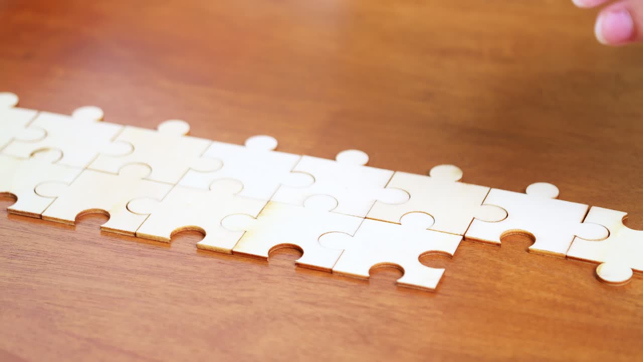 A close-up view of hands piecing together a puzzle illustrating focus and cognitive engagement