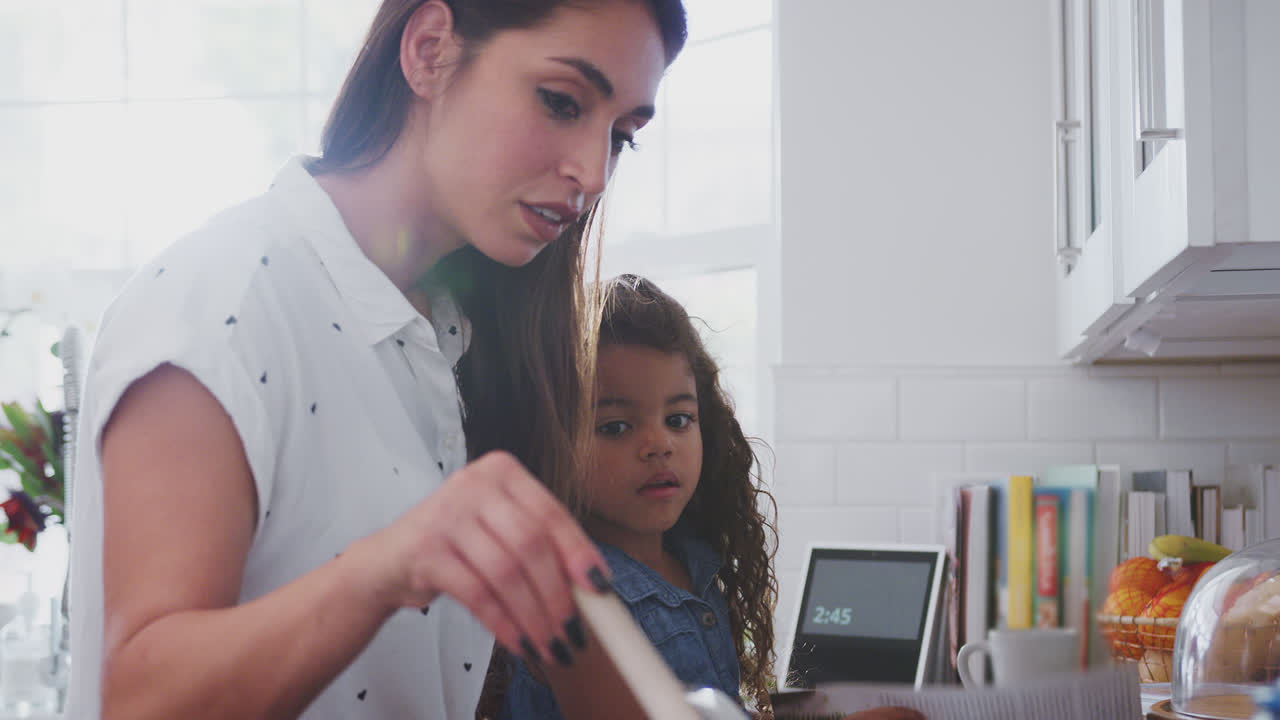 mujer hispana y hija joven cocinando juntos en la cocina en la cocina, de cerca, vista lateral