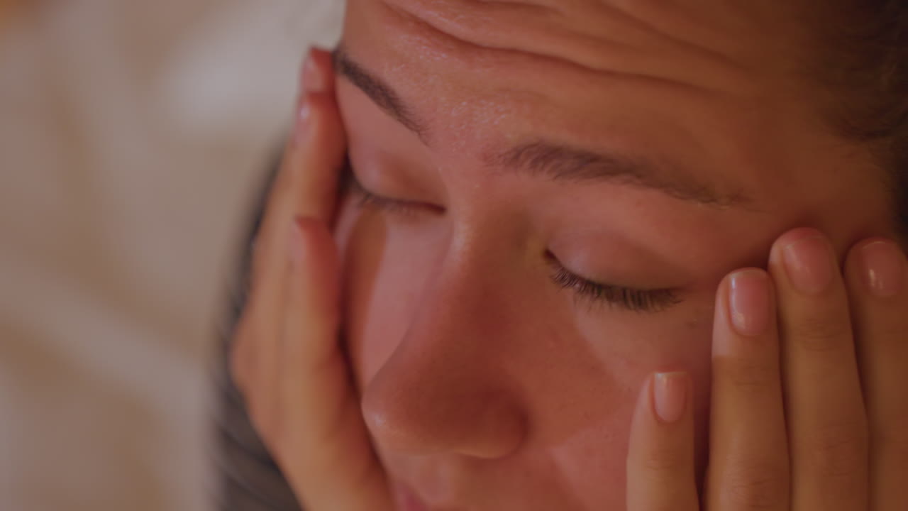 Ospite che riposa dopo un lungo viaggio. Un visitatore dell'hotel si massaggia delicatamente gli occhi stanchi sotto la luce del mattino. L'ospite in hotel si rilassa gradualmente mentre la luce soffusa del sole filtra attraverso le tende dopo il volo.