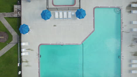 downward angle drone shot of swimming pool at hotel or resort