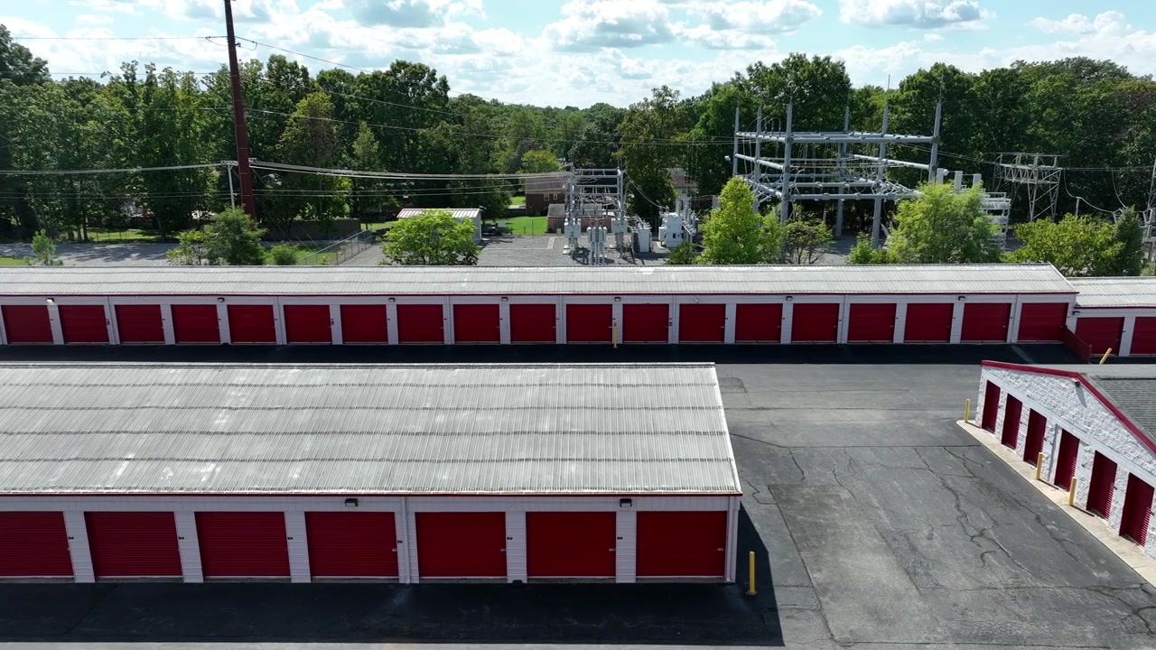 Garage rossi e unità di self-storage a noleggio in un sobborgo americano. Giornata estiva soleggiata, ampia ripresa aerea laterale.